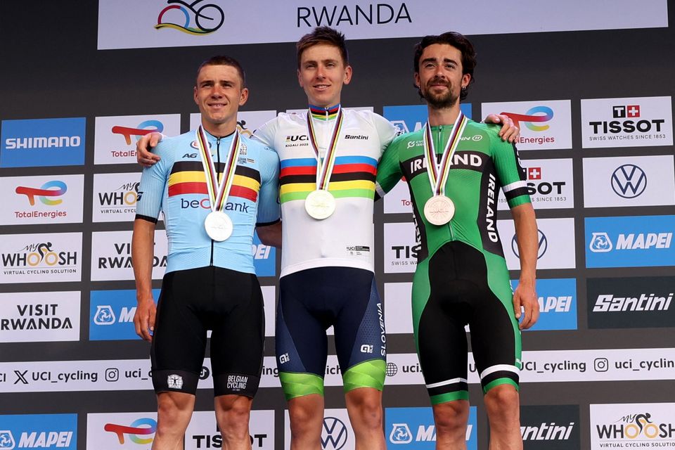 Slovenia's Tadej Pogacar celebrates on the podium after winning the Men's Elite Road Race with second-placed Belgium's Remco Evenepoel and third-placed Ireland's Ben Healy at the UCI Road World Championships 2025 in Kigali, Rwanda
